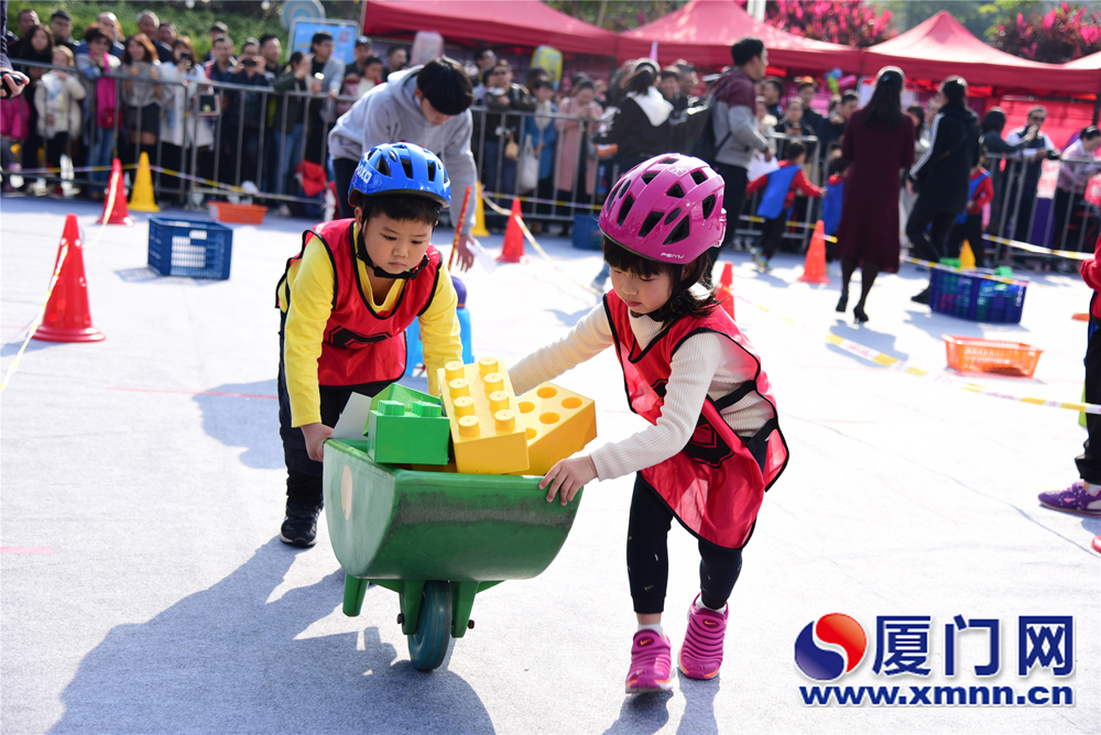  Two children are carrying blocks to build a house in the capacity competition.  [Photo/xmnn.cn]