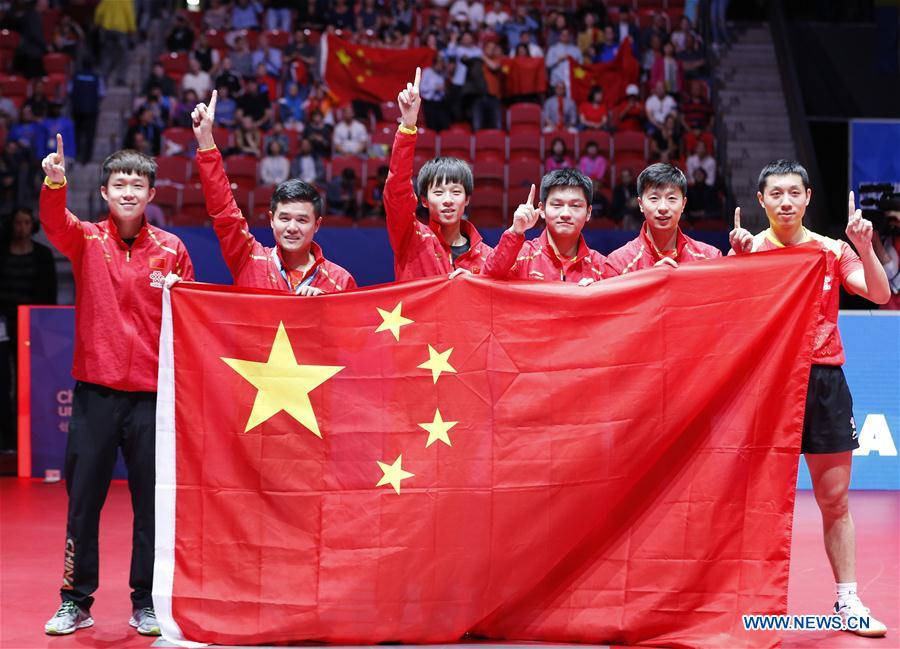 China's players and coach Liu Guozheng (2nd L) celebrate with a Chinese national flag after Men's group final between team China and team Germany at the 2018 World Team Table Tennis Championships in Halmstad, Sweden, May 6, 2018. Team China won the final 3-0 and claimed the title of the event. (Xinhua/Ye Pingfan)