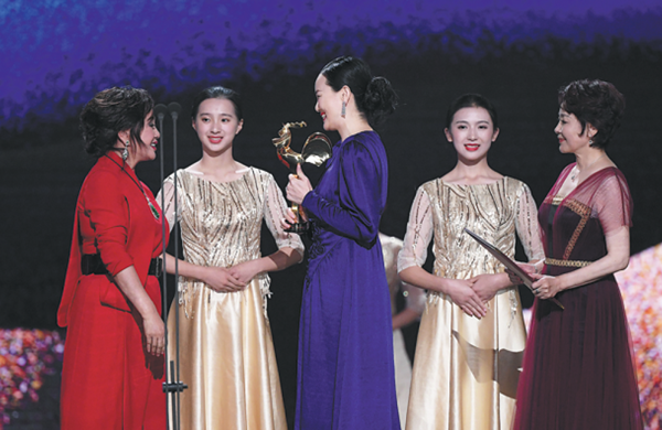 Yong Mei, lead actress in So Long, My Son, (wearing blue dress) is named best actress at the Golden Rooster Awards in Xiamen, Fujian province, on Nov 23. [Photo/Xinhua]