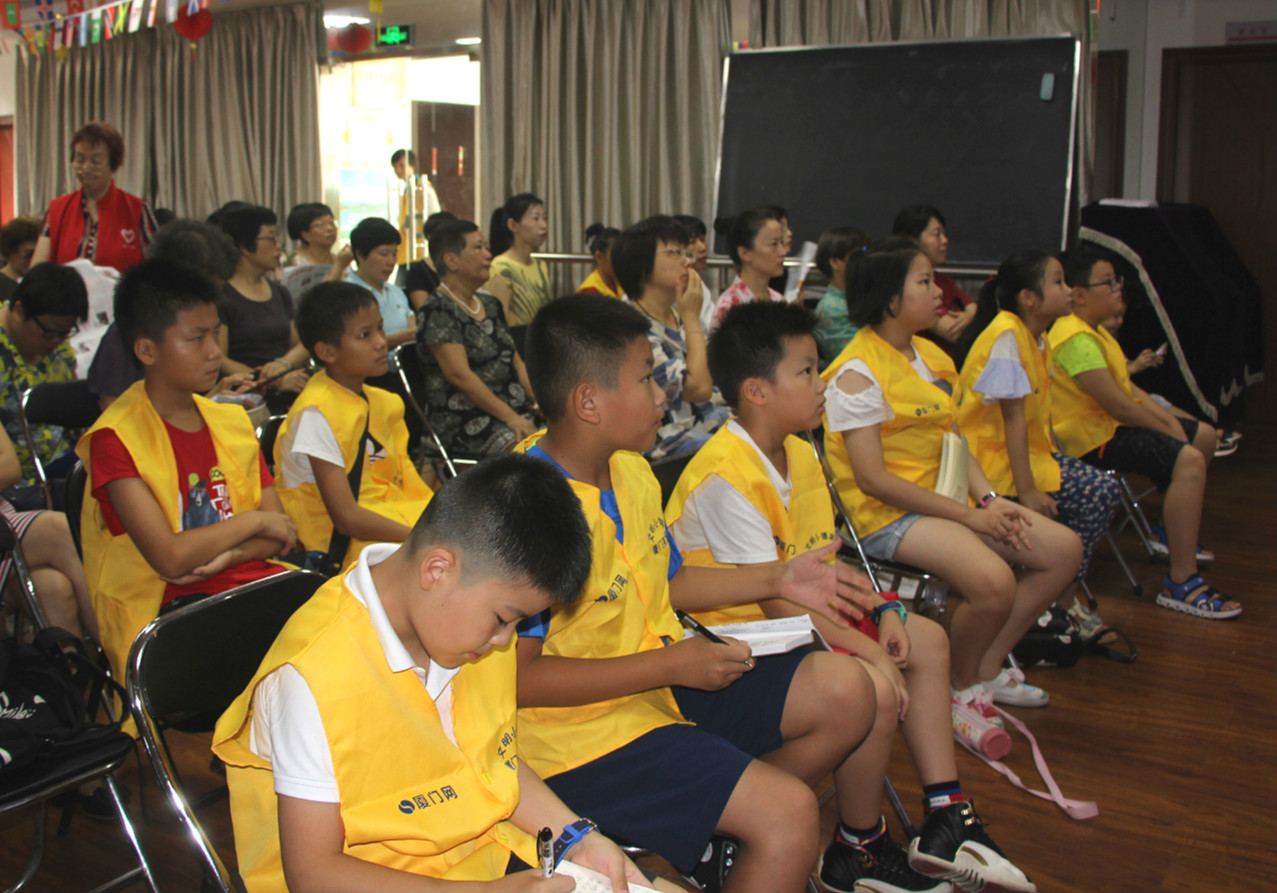 Young reporters from xmenglish.cn, the city’s English portal, listen carefully to the speaker Alex.